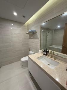 a bathroom with a sink and a toilet and a mirror at BRG Premium Apartments in Hai Phong +18 photos