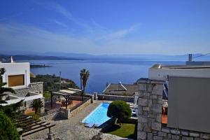 a house with a swimming pool and a view of the water at Malvazios Villas Azure Sea Villa in Gythio