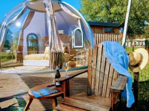 a wooden bench sitting on a deck with a glass dome at La Bulle des alpagas in Herry