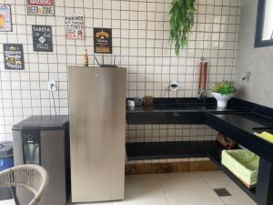 a kitchen with a refrigerator in a restaurant at Paraíso à vista Cobertura Linear Canto Nobre in Guarapari