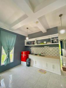 a kitchen with white cabinets and a blue wall at Dajon#4-Barkada Generator & starlink in General Luna