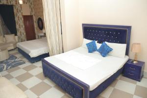 a bedroom with two beds with blue pillows at Sehrai Royal Villa in Multan