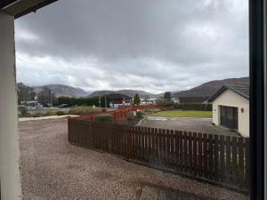 a view of a yard with a fence and mountains at Kildonan House Bed and Breakfast in Corpach +17 photos