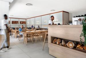 a bakery with two men standing at a counter with bread at Crayfish Penthouse - The Onyx Cape Town in Cape Town
