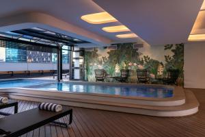 a swimming pool in a hotel lobby with a mural at Crayfish Penthouse - The Onyx Cape Town in Cape Town
