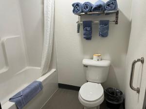 a bathroom with a white toilet and a tub and a shower at The Grove Inn and Suites in Eagle Grove +29 photos