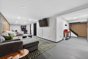 a living room with a couch and a tv at Radcliffe Ride Out Modern Bella Vista Retreat- Game Room, Fire Pit, Pet Friendly - Sleeps 10 in Bella Vista