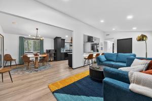 a living room with a blue couch and a table at Radcliffe Ride Out Modern Bella Vista Retreat- Game Room, Fire Pit, Pet Friendly - Sleeps 10 in Bella Vista