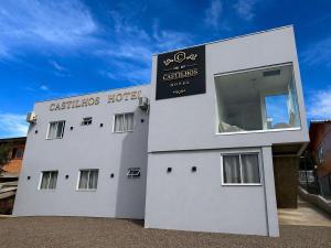 a white building with a sign for a restaurant at Castilhos Hotel in Barracão