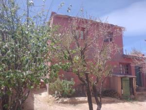 an old red house with trees in front of it at La Ollita in Humahuaca