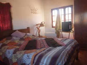a bedroom with a bed with a quilt on it at La Ollita in Humahuaca