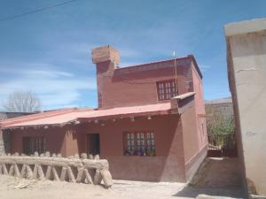 a pink house with a fence in front of it at La Ollita in Humahuaca
