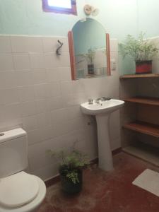 a bathroom with a sink and a toilet and a mirror at La Ollita in Humahuaca