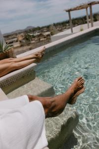 a man laying on the edge of a swimming pool at CasaBlancoMadera in Todos Santos