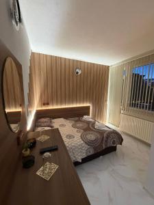 a bedroom with a bed and a table and a window at Teo's Guest House in Dospat