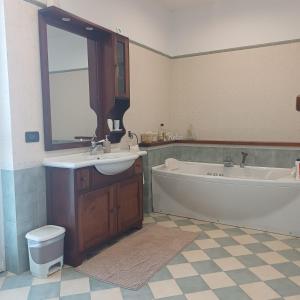 a bathroom with a tub and a sink and a tub and a mirror at ACERO ROSSO in Pianfei
