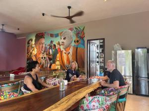 a group of people sitting at a bar at Casa Mexico Lindo - Boutique Hostel in Bacalar