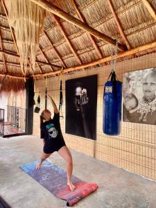 a young girl doing a yoga pose on a mat at Casa Mexico Lindo - Boutique Hostel in Bacalar