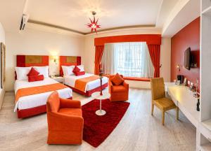 a hotel room with two beds and two chairs at Hotel Andante in Puebla