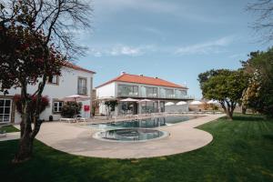 a building with a swimming pool in front of a house at Convento do Seixo Boutique Hotel & Spa in Fundão