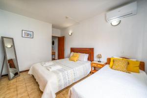 a bedroom with two beds and a mirror at Sweet home rp – t1 em portimão in Portimão