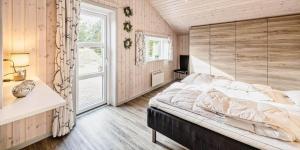 a bedroom with a large bed and a window at VE040-Vejers-Strand-Jafdalvej-5 in Vejers Strand