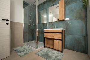 a bathroom with a shower and a sink and a mirror at Secret Garden Apartman in Varaždin
