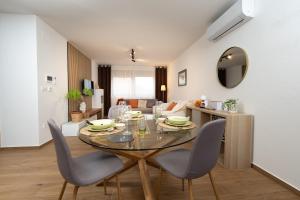 a dining room and living room with a table and chairs at Secret Garden Apartman in Varaždin