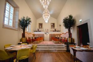 a restaurant with tables and chairs and a chandelier at Convento do Seixo Boutique Hotel & Spa in Fundão