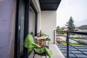 a balcony with a table and chairs with a view at Secret Garden Apartman in Varaždin +6 photos