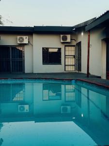 a swimming pool in front of a house at Ashridge Guesthouse & Safaris in Hazyview