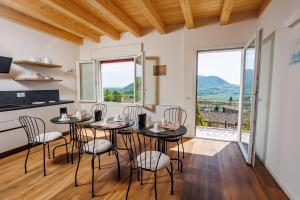 a dining room with a table and chairs and windows at Il Sentiero di Arquà in Arquà Petrarca