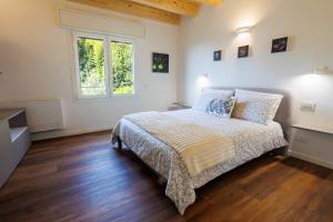 a white bedroom with a bed and a window at Il Sentiero di Arquà in Arquà Petrarca