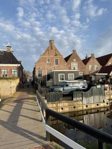 a group of houses and a canal with a car at Irene 2 in Hindeloopen