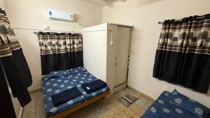 a small room with a bed and a window at Rudraksh Homestay in Dwarka