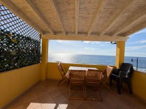 a balcony with a table and chairs and the ocean at La Casa Gialla in Cala Gonone