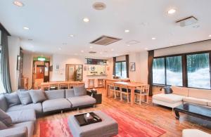 ein Wohnzimmer mit einem Sofa und einem Tisch in der Unterkunft Morino Lodge - Hakuba in Hakuba
