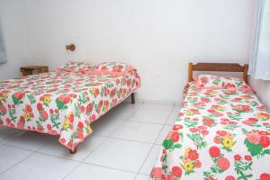 two beds sitting next to each other in a room at Chale 4 com Churrasqueira e Ar a 200m da Praia in Prado