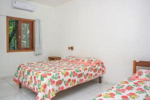 a bedroom with two beds and a window at Chale 4 com Churrasqueira e Ar a 200m da Praia in Prado +22 photos