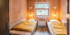 two beds in a room with a window at VE125-Vejers-Strand-Aavej-19 in Vejers Strand