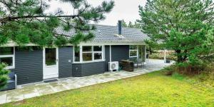 a blue house with a patio in front of it at VE125-Vejers-Strand-Aavej-19 in Vejers Strand