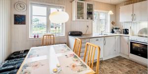 a kitchen with a table and chairs in a room at VE147-Vejers-Strand-Violvej-16 in Vejers Strand +17 photos