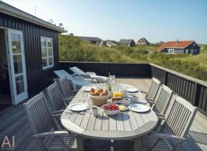 a wooden table with a bowl of fruit on a deck at VE147-Vejers-Strand-Violvej-16 in Vejers Strand