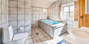 a bathroom with a tub and a toilet and a sink at VE047-Vejers-Strand-Jafdalvej-91 in Vejers Strand +22 photos