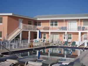 a resort with a swimming pool and chairs and a building at Sierra Suites in Daytona Beach