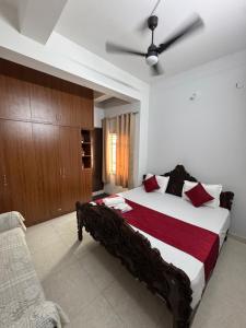 a bedroom with a large bed and a ceiling fan at Sofra service apartment by LUXE with swinging pool in Mysore +42 photos