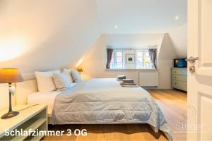 a bedroom with a bed and a desk and a window at Lavendelhaus in Oevenum
