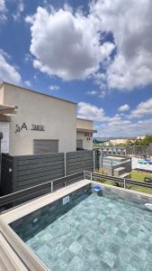 a swimming pool in front of a building at 54You in Ahuzat Barak
