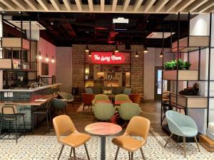 a restaurant with chairs and tables and a bar at Canvas Moncton, Tapestry Collection By Hilton in Moncton