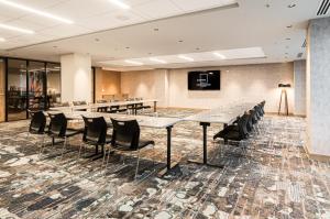 a conference room with tables and black chairs at Canvas Moncton, Tapestry Collection By Hilton in Moncton